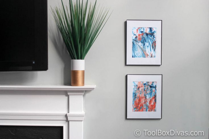 Abstract marble wall art using shaving cream hanging on the wall next to a fireplace mantle